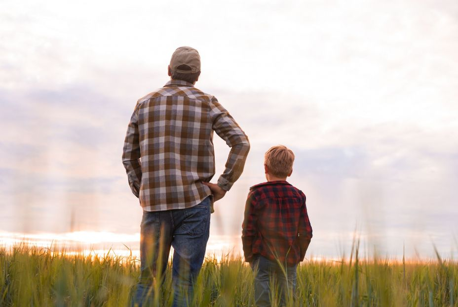 bigstock Farmer And His Son In Front Of 469495391