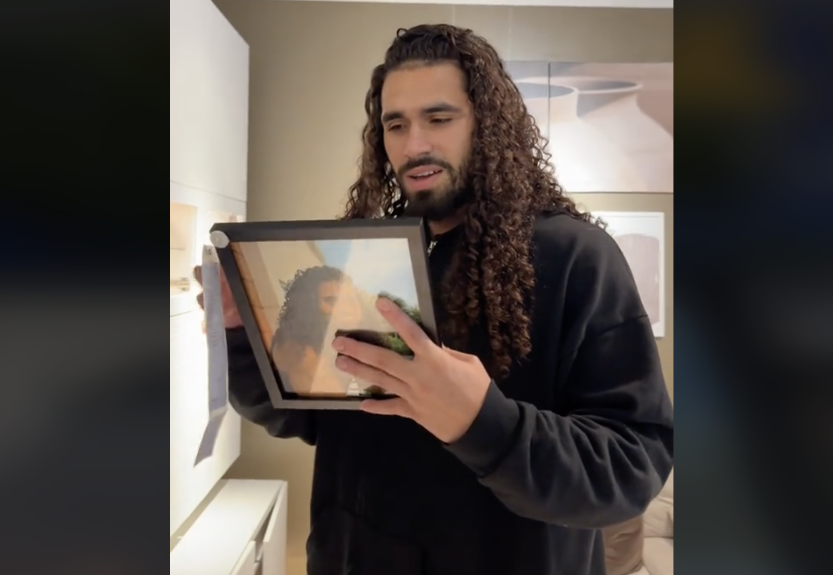 Una mujer coloca un marco con una foto de su marido en Ikea para ver su reacción