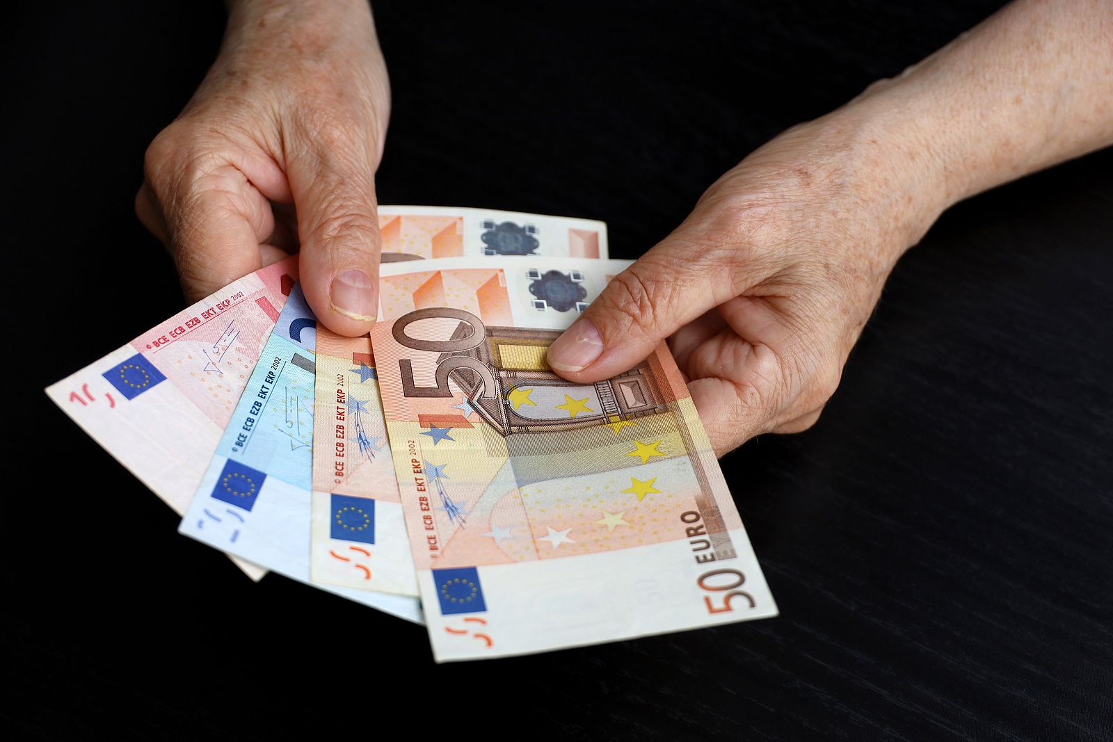 bigstock Elderly Woman With Euro Notes  455741875