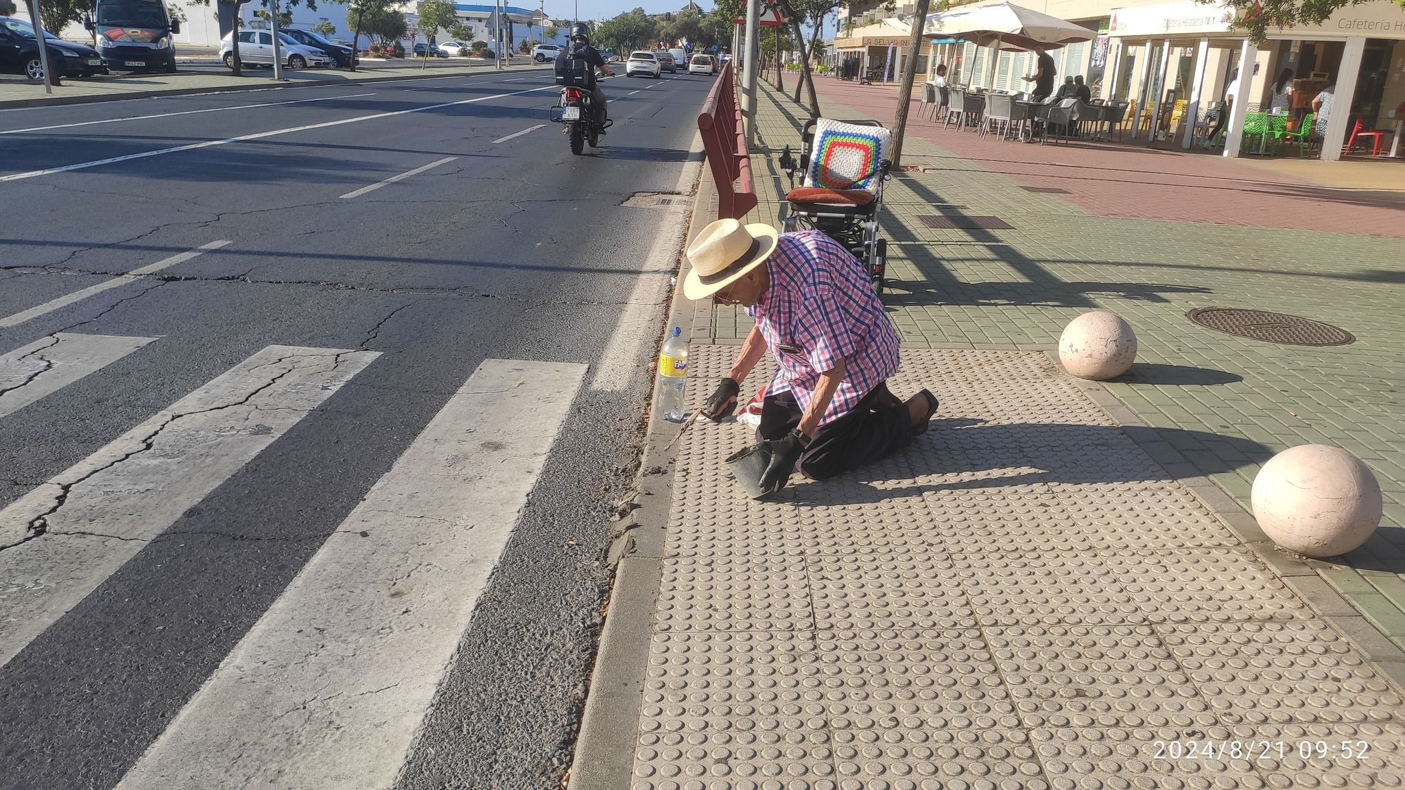 Un hombre mayor de Aljaraque (Huelva) arregla un bordillo para poder pasar con su silla de ruedas