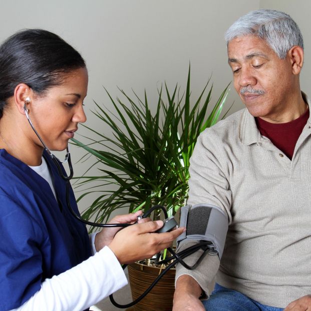 Doctora midiendo la presión arterial de un paciente. Fuente: Bigstock