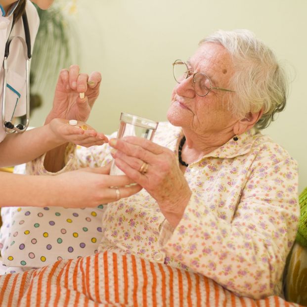 Mujer tomándose medicación. Fuente: Bigstock