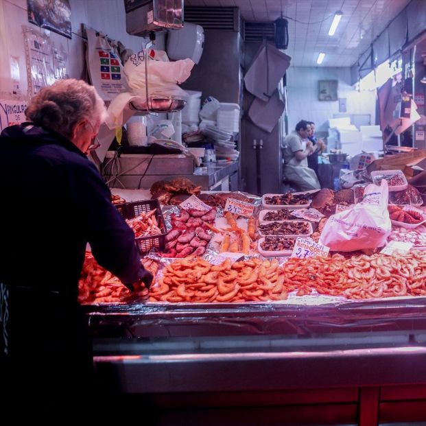 Un hombre compra unos langostinos antes de la cena de Nochebuena en un mercado (2023). Fuente: Ricardo Rubio / Europa Press