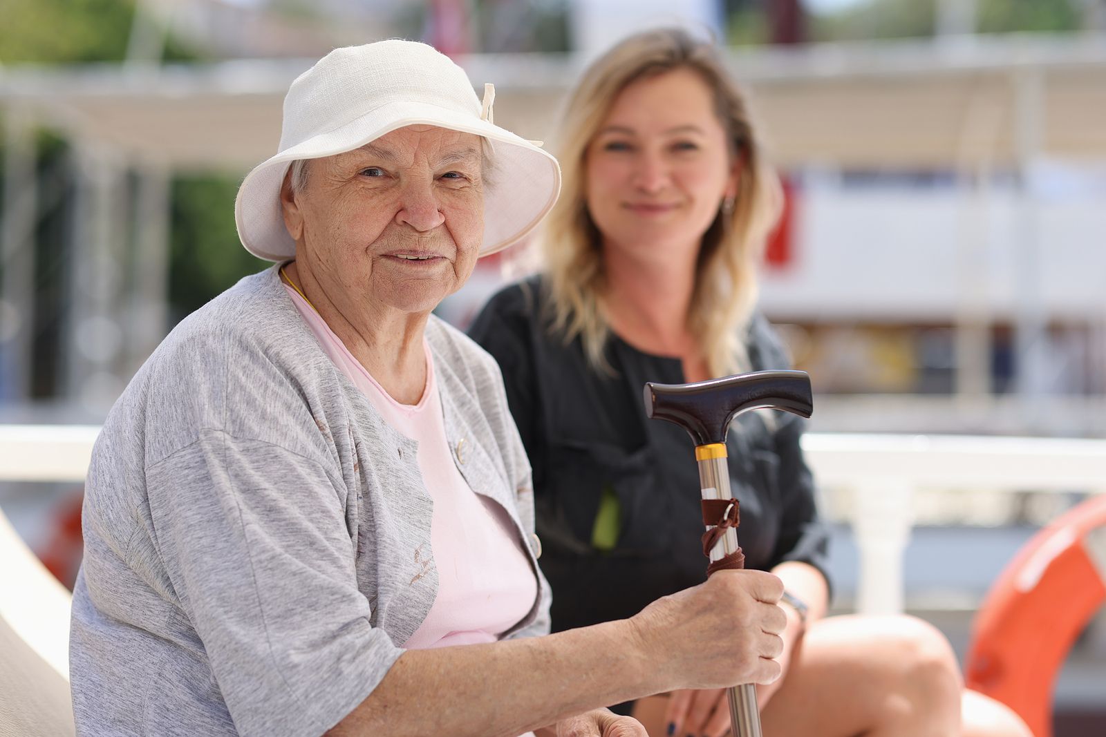 bigstock Elderly Woman With Cane Sits W 455313943