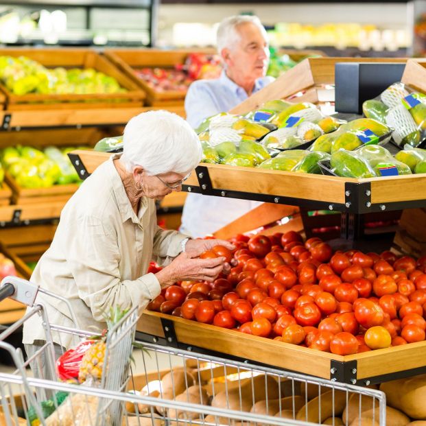 Dos personas comprando fruta y verdura en un supermercado. Fuente: Bigstock