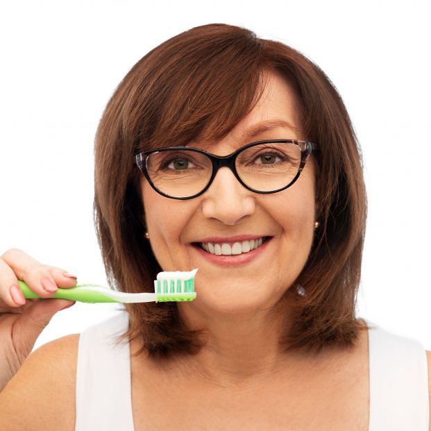 Mujer lavándose los dientes. Fuente: Bigstock