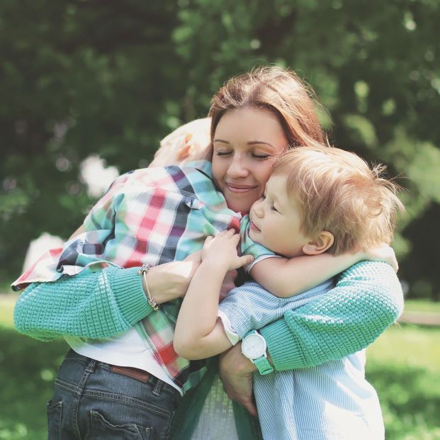 Madre abrazando a sus hijos. Fuente: Bigstock