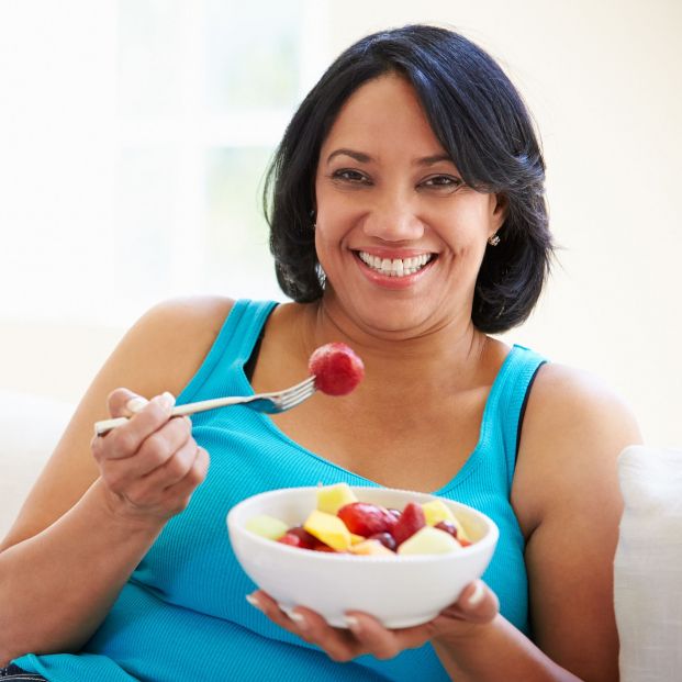 Mujer comiendo fruta. Fuente: Bigstock