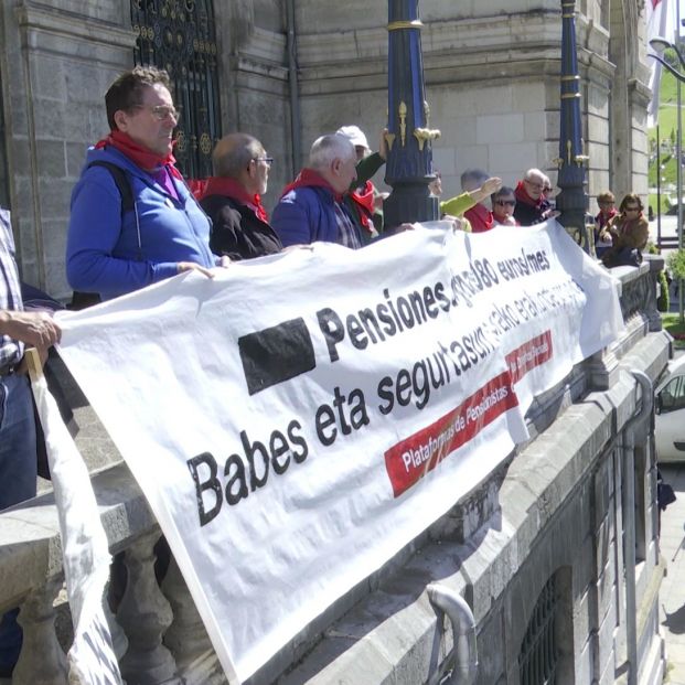 Un grupo de pensionistas despliegan una pancarta en el balcón del ayuntamiento de Bilbao